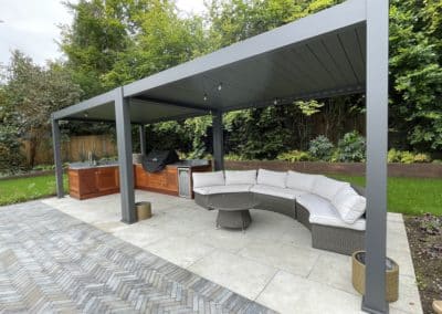 Two louvred aluminium pergolas cover the outdoor kitchen and seating area so that the area can be used throughout the year.