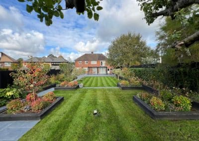 A large garden broken into different garden rooms with plants softening the strong lines.